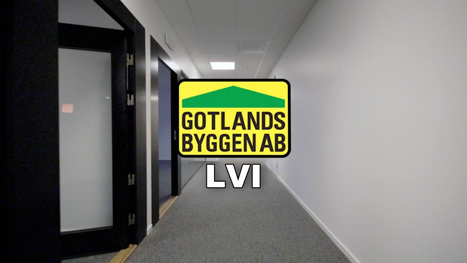 En ljus kontorskorridor med glasdörrar, med Gotlands Byggen AB:s gulgröna logotyp och texten LVI.