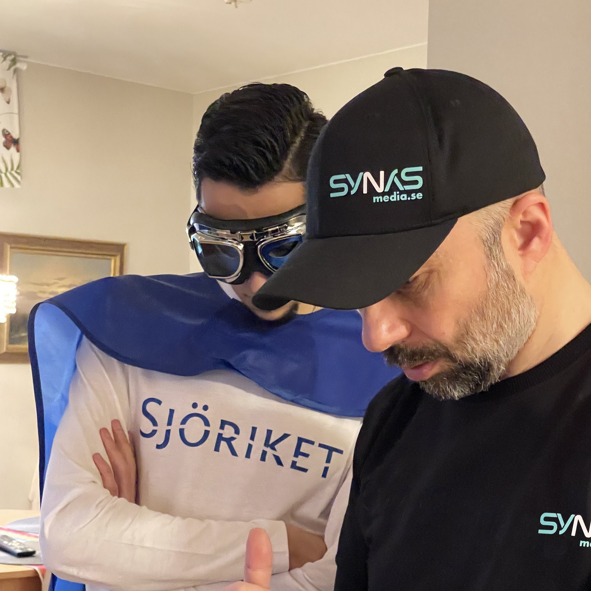 Bakom kulisserna: skådespelare i Sjöriket-tröja och pilotglasögon går igenom nästa tagning med filmteamet.